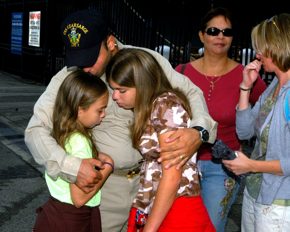 US Navy 070730-N-4014G-027 Senior Chief Quartermaster Victor Rivera hugs his daughters before boarding amphibious assault ship USS Kearsarge (LHD 3)