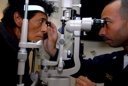 US Navy 070806-N-6081J-005 Cmdr. Octavio Borges, an ophthalmologist aboard the Military Sealift Command (MSC) hospital ship USNS Comfort (T-AH 20), examines a Peruvian patient photo