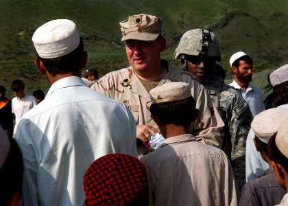 US Navy 070802-N-3385W-768 Commanding Officer Provincial Reconstruction Team Khost, U.S. Navy Cmdr. David Adams hands out candy to school children before the groundbreaking ceremony in Jaji Maidan for a new school building