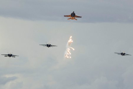US Navy 070804-N-5387K-004 Decoy flares fall beneath an F-A-18 Hornet from the Strike Fighter Squadron (VFA) 27 during an aerial change of command over USS Kitty Hawk (CV 63)