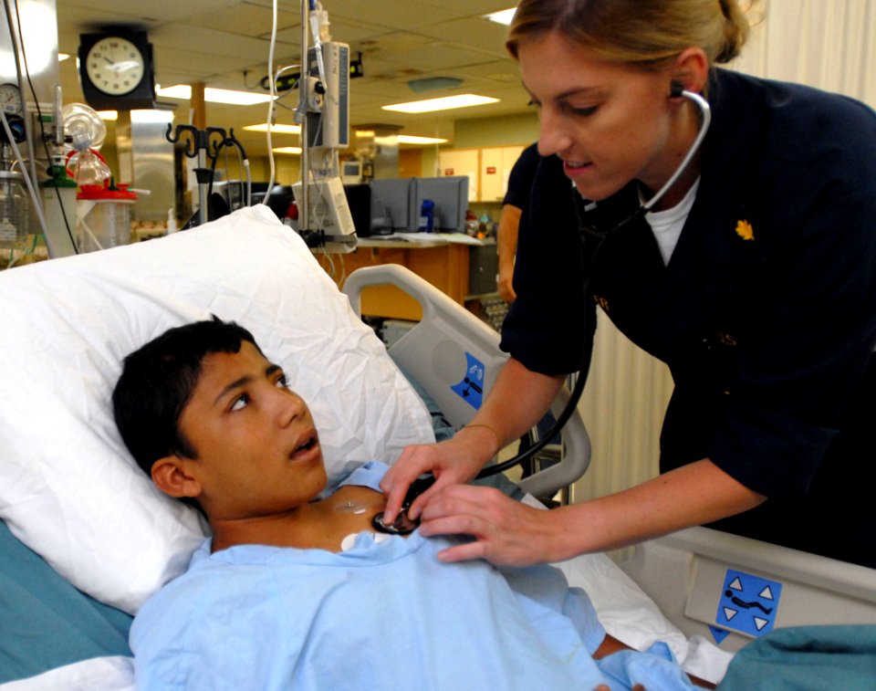 US Navy 070731-N-4238B-007 Lt. Megan Zeller, an intensive care unit nurse, checks the vital signs of patient, while he recovers after surgery aboard the hospital ship USNS Comfort (T-AH 20)