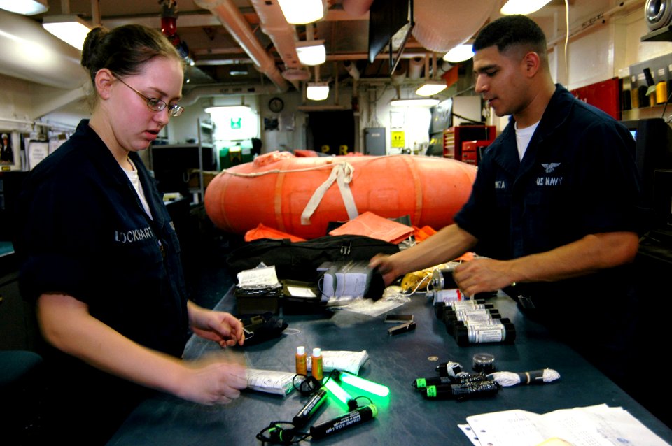 US Navy 070801-N-3136P-009 Aircrew Survival Equipmentman Airmans Jessica Lockhart (left), and Rudy Inzunza inventory a C-2A Greyhound's life raft kit in USS Kitty Hawk (CV 63) paraloft shop