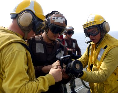 US Navy 070804-N-1598C-077 Aviation Boatswain's Mate (Handler) 2nd Class Mark Torres of Washington Heights, N.Y., trains Sailors on the different settings of a vari-nozzle during a series of fire-fighting flight deck drills