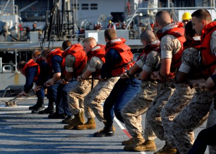 US Navy 070802-N-0841E-088 Sailors and Marines aboard amphibious transport dock USS Ponce (LPD 15) heave on the line in order to properly seat the fuel probe during a replenishment at sea