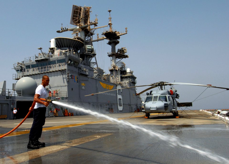 US Navy 070807-N-3211R-004 Aviation Boatswain's Mate (Handling) Airman Lawrence Llorente, a native of Vigan City, Philippines, use a fire hose to wash salt off the flight deck during a fresh water wash down