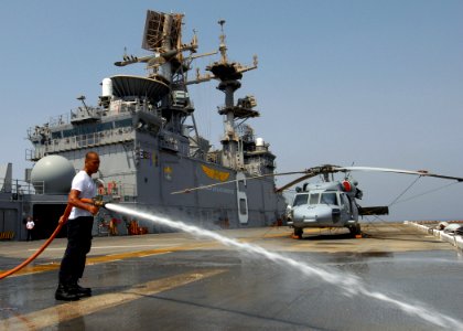 US Navy 070807-N-3211R-004 Aviation Boatswain's Mate (Handling) Airman Lawrence Llorente, a native of Vigan City, Philippines, use a fire hose to wash salt off the flight deck during a fresh water wash down
