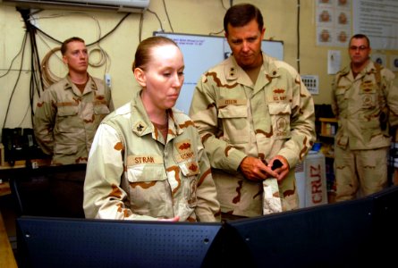 US Navy 070806-N-8275M-106 Rear Adm. Richard Cellon, commander 1st Naval Construction Division, receives a brief from Builder 1st Class Katarina Stran of the 30th Naval Construction Regiment (30 NCR) in the Combat Operations ce