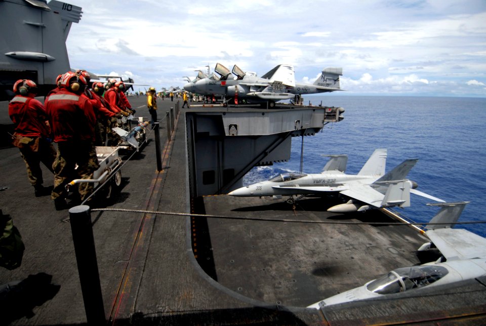 US Navy 070807-N-6326B-026 Sailors and Marines ensure the safe operation of elevator 2 while lowering two F-A-18A Hornets, assigned to the Red Devils of Marine Fighter Attack Squadron (VMFA) 232