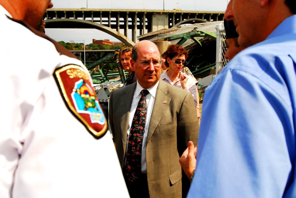 US Navy 070808-N-4515N-219 Secretary of the Navy (SECNAV) the Honorable Donald C. Winter, center, meets with Department of Defense, federal, state, and local officials at the scene of the I-35 bridge collapse