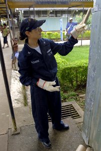 US Navy 070808-N-4954I-032 perations Specialist 3rd Class Julie Blackmore removes old paint with a steel brush at Modilon General Hospital in support of a community relations project