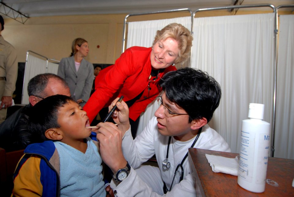 US Navy 070808-N-8704K-450 Under Secretary for Diplomacy and Public Affairs Karen Hughes observes Dr. Christian Cruz-Mendoza providing primary medical care for Jose Corien, at the Miguel Grau School