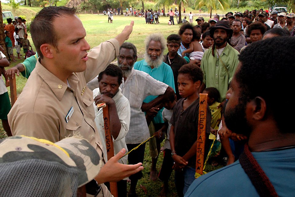US Navy 070808-N-9421C-114 Lt. Cmdr. Andrew Schiemel from Naval Medical Center San Diego, explains to an interpreter how patients will receive treatment at Bunabun Health Center