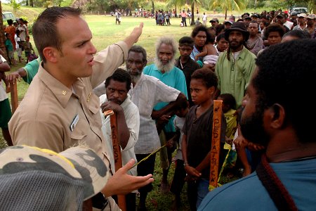 US Navy 070808-N-9421C-114 Lt. Cmdr. Andrew Schiemel from Naval Medical Center San Diego, explains to an interpreter how patients will receive treatment at Bunabun Health Center photo