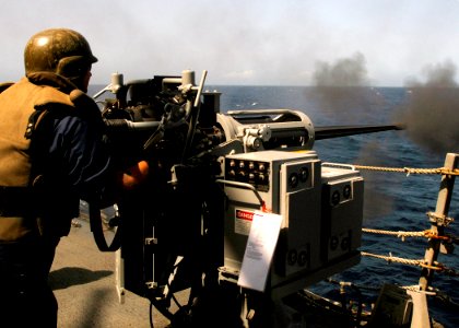 US Navy 070807-N-8132M-094 A Sailor fires a 25mm chain gun during a gun qualifications and small craft action team (SCAT) training exercise aboard the guided-missile destroyer USS Arleigh Burke (DDG 51)