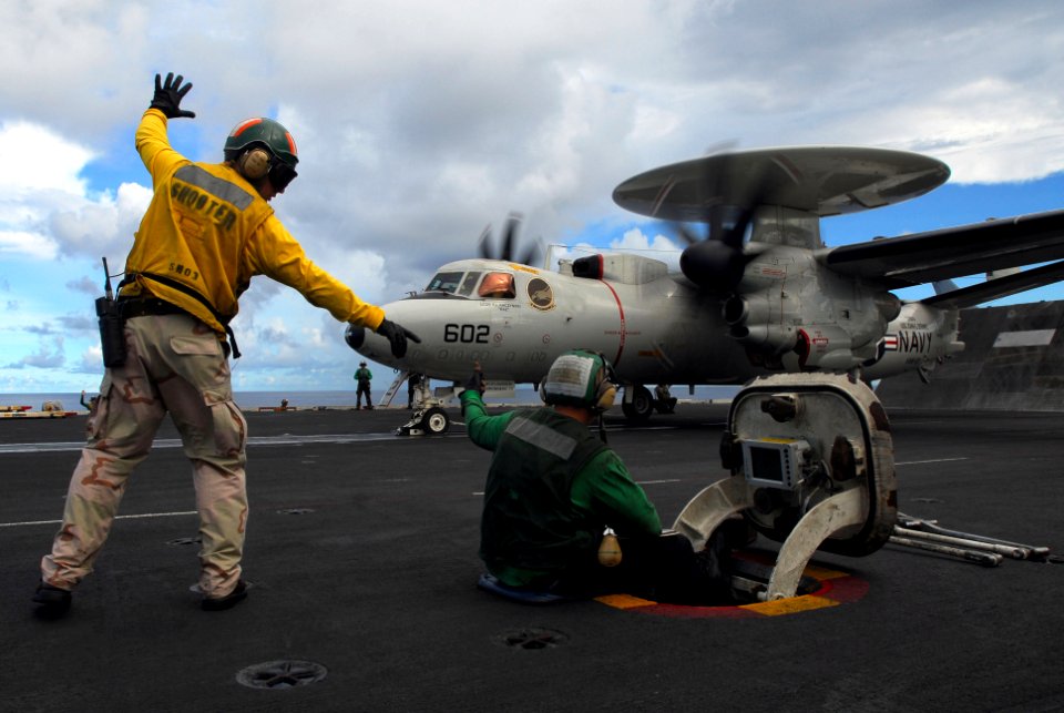 US Navy 070809-N-2659P-040 Lt. Christopher Smith signals to Aviation Boatswain's Mate (Equipment) Airman James Christaudo before launching an E-2C Hawkeye assigned to Carrier Airborne Early Warning Squadron (VAW) 112