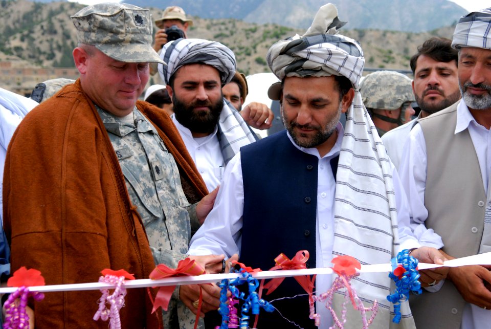 US Navy 070809-N-3385W-761 Commanding Officer Provincial Reconstruction Team Khost, U.S. Navy Cmdr. David Adams and the Governor of Afghanistan's Khowst province, Arsala Jamal, in a uniquely Afghan tradition, cut the ribb