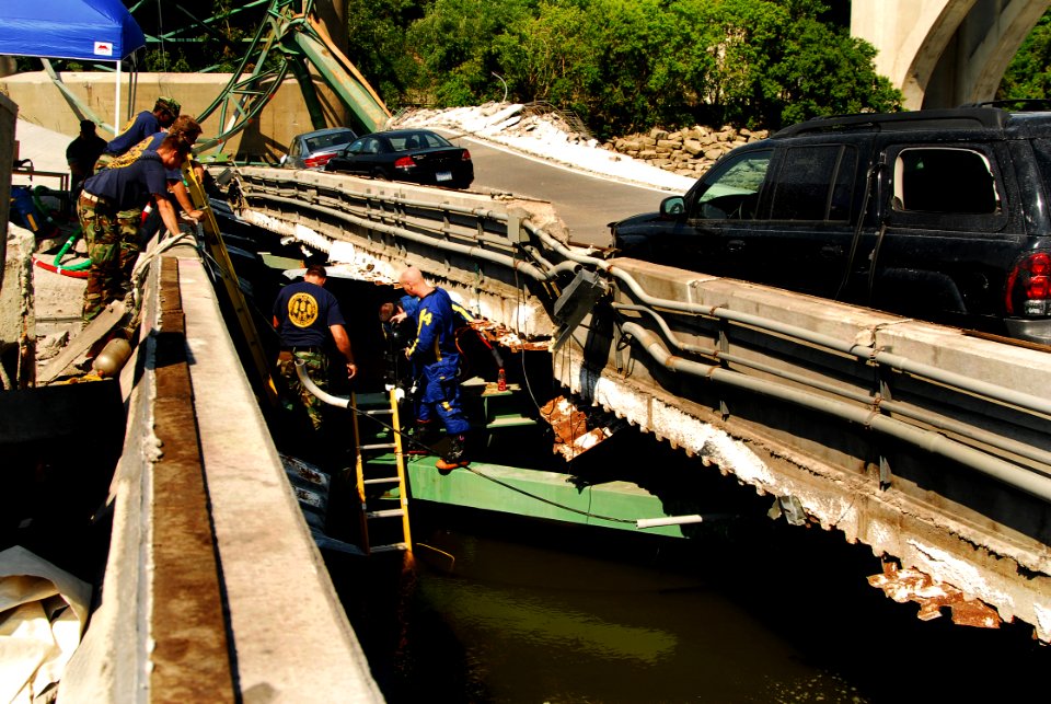 US Navy 070807-N-4515N-476 Navy divers from Mobile Diving and Salvage Unit (MDSU) 2 from Naval Amphibious Base Little Creek, Va., prepare to enter the water at the site of the I-35 bridge collapse