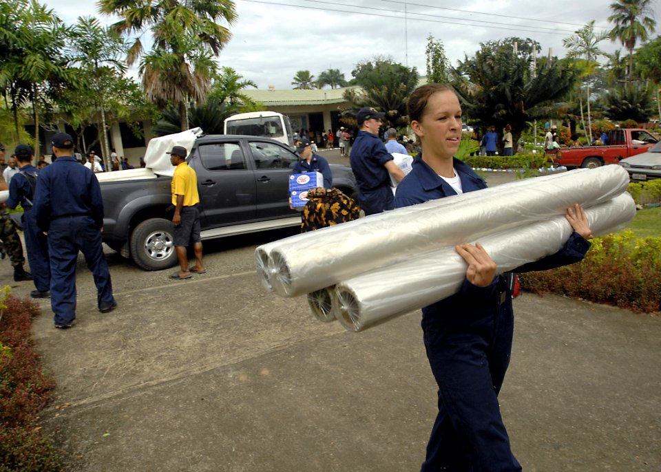 US Navy 070808-N-4954I-008 Cryptographic Technician (Technical) Seaman Sarah Curl carries rolls of plastic sheeting in preparation for a community relations project at Modilon General Hospital in support of Pacific Partnership