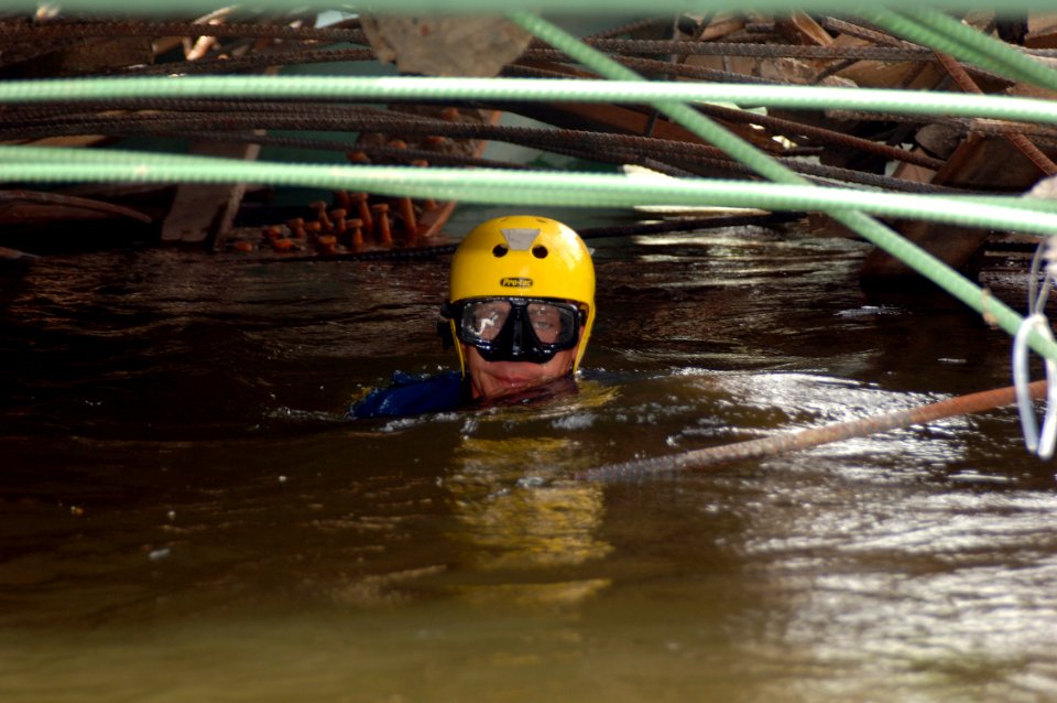 US Navy 070808-N-3093M-014 A member of Mobile Diving and Salvage Unit (MDSU) 2 from Naval Amphibious Base Little Creek, Va., swims through debris searching for victims of the I-35 bridge collapse