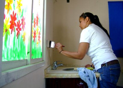 US Navy 070810-N-3211R-022 Intelligence Specialist 1st Class Veronica TorresSilva uses a paint brush to touch-up scuff spots in a classroom at the Dubai Autism Center