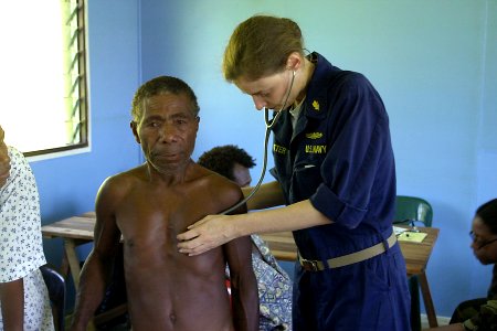 US Navy 070809-N-9195K-011 Cmdr. Elizabeth Satter uses a stethoscope to listen to a local man's breathing during a medical civic action program (MEDCAP) at Bunabun Heath Center photo