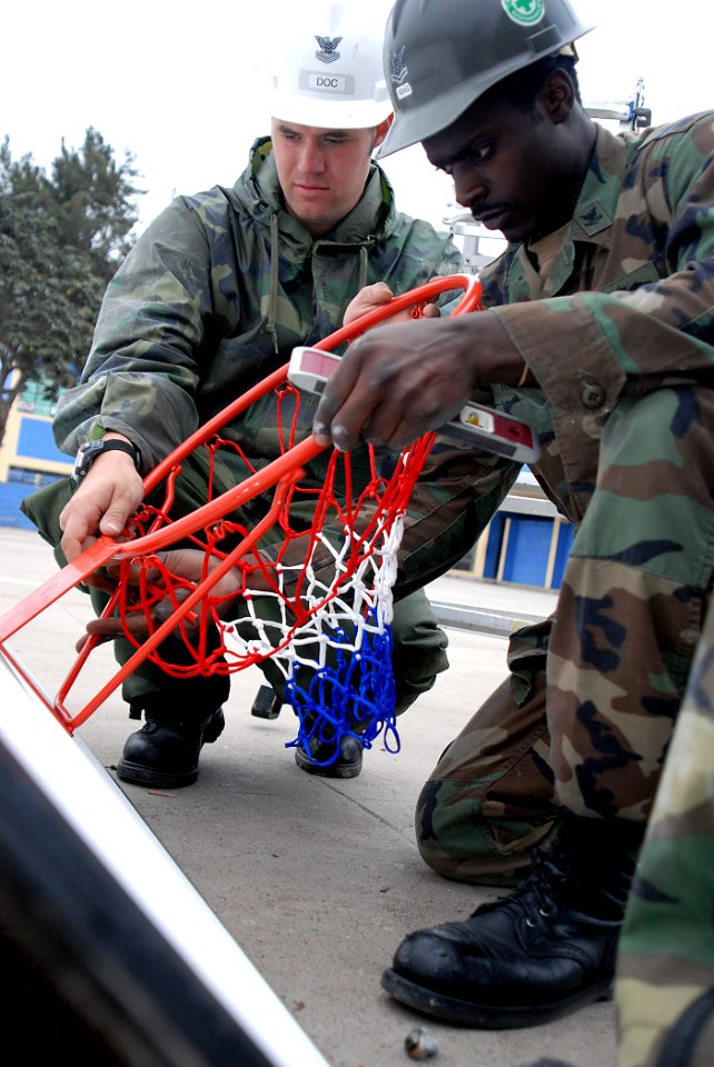 US Navy 070812-N-6081J-244 Utilitiesman 2nd Class Charlie King (right) and Coast Guard Health Services Technician 2nd Class Andrew Schultz repair a basketball goal at the Jose Olaya School in Trujillo