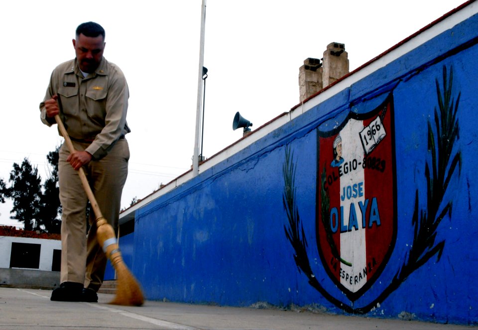 US Navy 070812-N-6081J-042 Lt. Chris Hawkins, a patient encounter tracking officer, aboard the Military Sealift Command (MSC) hospital ship USNS Comfort (T-AH 20), sweeps the courtyard of the Jose Olaya School in Trujillo, Peru