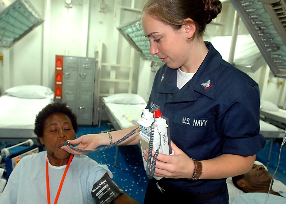 US Navy 070812-N-9421C-004 Hospital Corpsman 3rd Class Barbara Linnerooth takes a local man's temperature while he is recovering from surgery aboard the amphibious assault ship USS Peleliu (LHA 5)