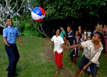 US Navy 070813-N-4954I-014 Indian navy Lt. Cmdr. Ashok Bhandari, a family practitioner, tosses a beach ball with local children at Ileg Clinic near Madang in support of Pacific Partnership photo