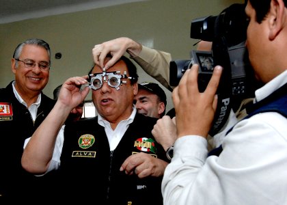 US Navy 070809-N-6278K-257 Luis Alva Castro, Peru's minister of interior, has eyeglasses fitted for him by an optometrist attached to Military Sealift Command hospital ship USNS Comfort (T-AH 20) photo