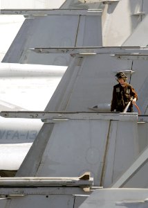 US Navy 070809-N-7981E-153 A plane captain assigned to the Kestrals of Strike Fighter Squadron (VFA) 137 washes down an F-A-18E Super Hornet on the flight deck of Nimitz-class aircraft carrier USS Abraham Lincoln (CVN 72)