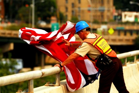 US Navy 070814-N-4515N-206 Hennepin County Sheriffs Deputy, Sgt. Rick O'Mara rearranges a American Flag that has become tangled in the wind