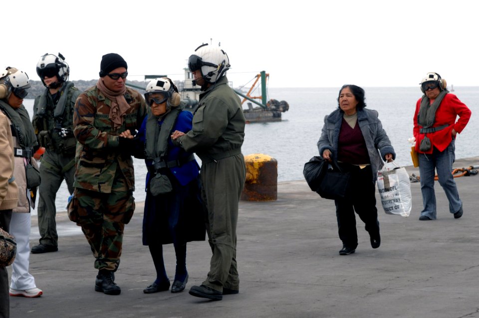 US Navy 070810-N-7088A-049 Master-at-Arms 2nd Class Jesus Rodriguez and Aviation Warfare Systems Operator 1st Class Carlos Hernandez assist an elderly patient who recently departed the Military Sealift Command (MSC) hospital sh