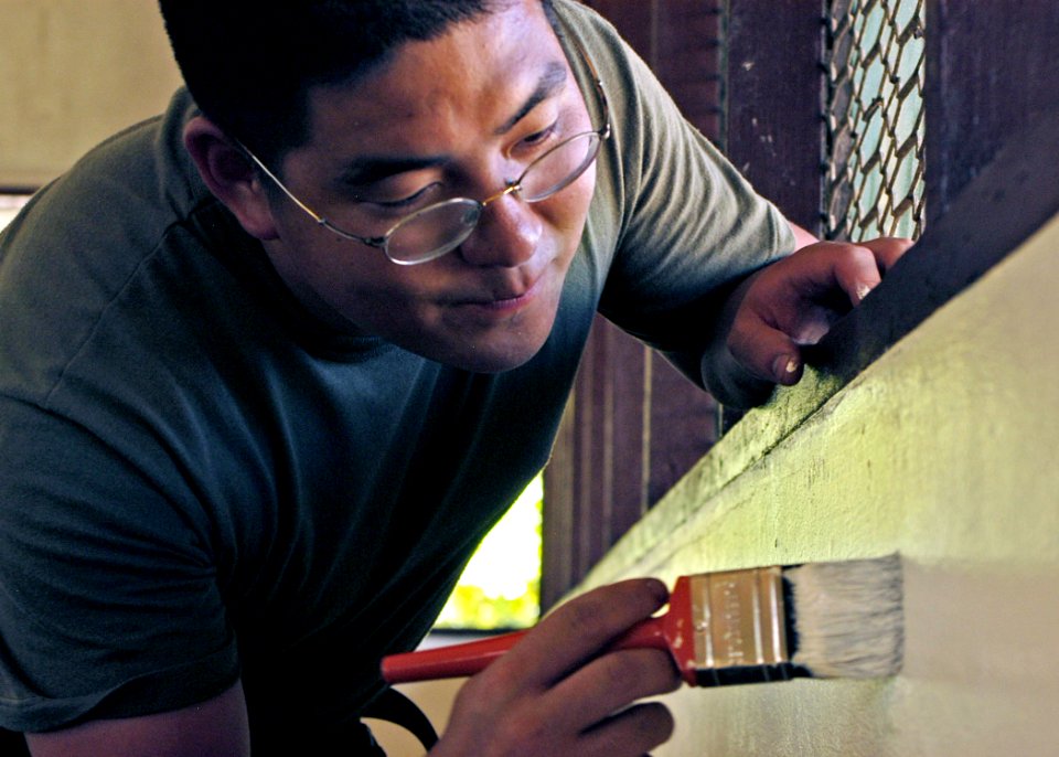 US Navy 070814-N-6999H-035 ospital Corpsman 3rd Class Ando Muneno attached to the 3rd Medical Battalion touches up a window ledge during an engineering civil-assistance program
