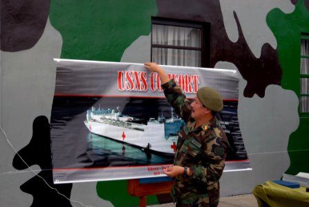 US Navy 070812-N-8704K-041 Peruvian army Maj. Carlos Perez hangs a sign featuring the Military Sealift Command (MSC) hospital ship USNS Comfort (T-AH 20), prior to a closing ceremony