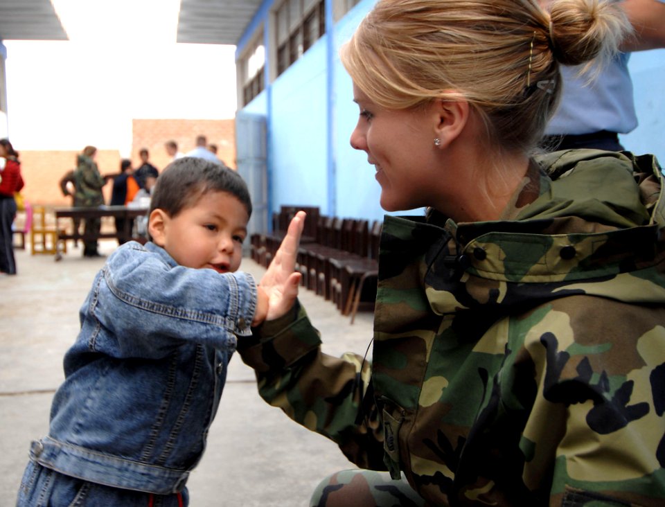 US Navy 070810-N-0194K-279 U.S. Air Force Staff Sgt. Sarah Boyll, an Air National Guard dental technician from the 181st Fighter Wing attached to hospital ship USNS Comfort (T-AH 20), high-fives a young child