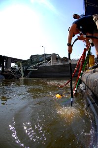 US Navy 070810-N-3093M-003 Navy Divers from Mobile Diving and Salvage Unit (MDSU) 2 from Naval Amphibious Base Little Creek, Va., enter the water during a salvage dive in the Mississippi River