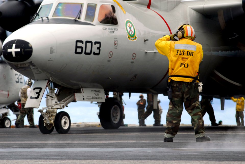 US Navy 070811-N-7883G-030 An aircraft director taxis an E-2C Hawkeye assigned to the Liberty Bells of Carrier Airborne Early Warning Squadron (VAW) 115 aboard the USS Kitty Hawk (CV 63)