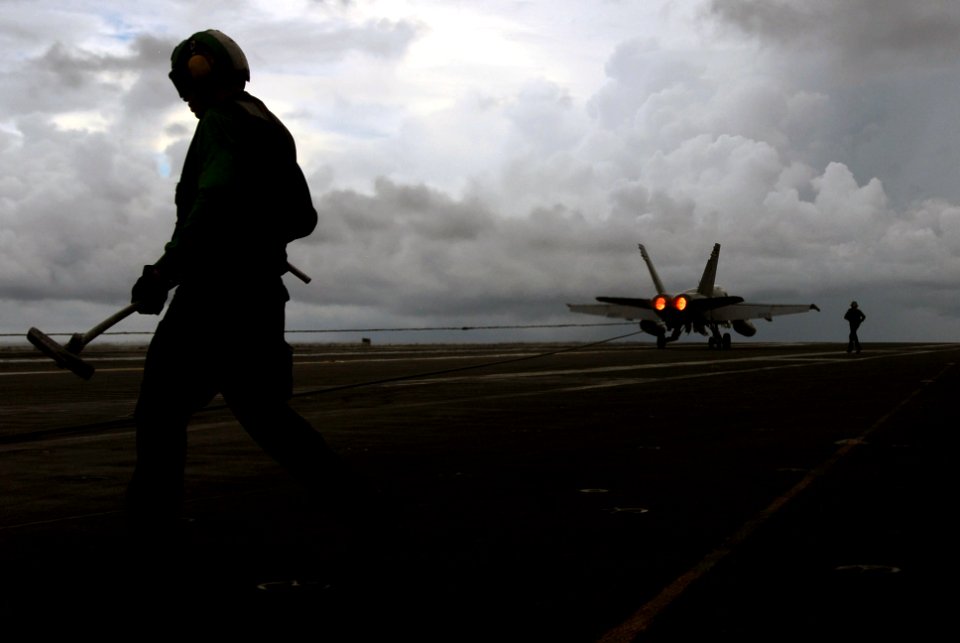 US Navy 070812-N-2659P-031 A Sailor assists with the arrested gear after an F-A-18C Hornet assigned to the