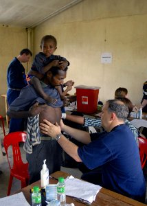 US Navy 070811-N-4267W-017 New Zealand Navy, Cmdr. John Duncan examines a man from Josephstaal during a medical civil-assistance program in support of Pacific Partnership 2007 photo