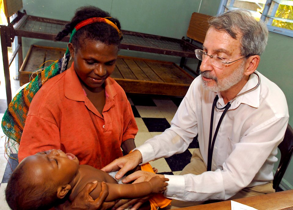 US Navy 070813-N-4954I-063 Dr. Lawrence Opas, a pediatrician with Project Hope, examines a local's baby during a medical civil-assistance program (MEDCAP) at Ileg Clinic near Madang