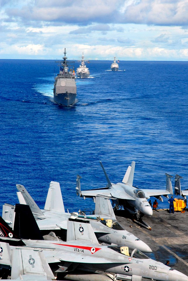US Navy 070814-N-0890S-011 USS Princeton (CG 59), USS John Paul Jones (DDG 53), and USS Pinckney (DDG 91) transit behind the nuclear-powered aircraft carrier USS Nimitz (CVN 68) during a joint photo exercise