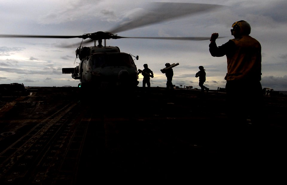 US Navy 070812-N-0684R-071 Landing signal enlisted Boatswain's Mate 1st Class Jared Klevis directs squadron personnel to load sonobouys on an SH-60B Seahawk assigned to the Wolfpack of Helicopter Anti-Submarine Squadron Light (