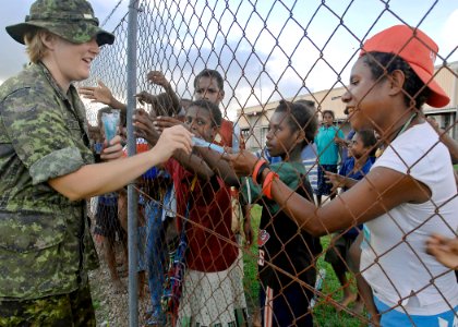 US Navy 070814-N-4954I-079 Sgt. Pattie-Lynne Powell, a dental assistant, with the Canadian Forces Dental Services, hands out toothbrushes to local children