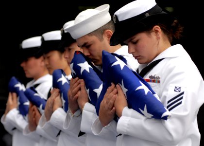 US Navy 070819-N-7981E-605 Flag bearers bow their heads in prayer during a burial at sea ceremony aboard Nimitz-class aircraft carrier USS Abraham Lincoln (CVN 72) photo