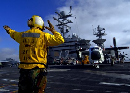 US Navy 070815-N-1229B-007 Aviation Boatswain's Mate (Handling) 2nd Class Dionisio Garza directs a C-2A Greyhound attached to the