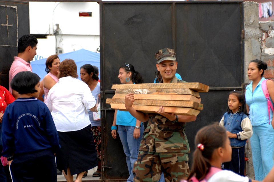 US Navy 070817-N-0194K-001 Navy Diver 2nd Class Allan Manco, a translator attached to Construction Battalion Maintenance Unit (CBMU) 202, carries supplies for the construction of handicapped-accessible ramps at Angelica Flores