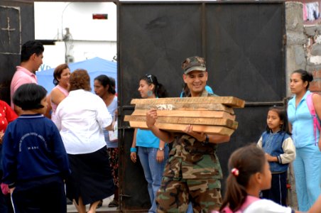 US Navy 070817-N-0194K-001 Navy Diver 2nd Class Allan Manco, a translator attached to Construction Battalion Maintenance Unit (CBMU) 202, carries supplies for the construction of handicapped-accessible ramps at Angelica Flores photo