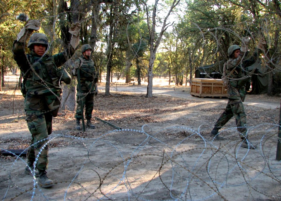 US Navy 070815-N-8547M-043 Seabees of Naval Mobile Construction Battalion (NMCB) 5 Communications Platoon lay triple strand concertina wire during Operation Bearing Duel 6-07