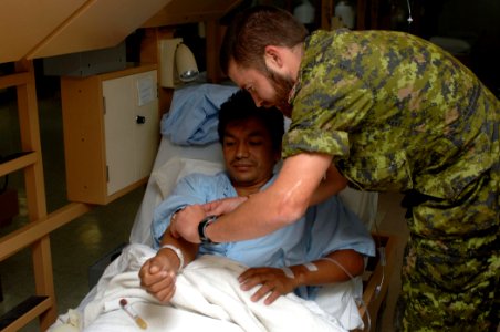 US Navy 070820-N-7088A-005 Lt. Leigh Aris, a member of the Canadian forces aboard Military Sealift Command hospital ship USNS Comfort (T-AH 20), prepares a patient who was recently operated on aboard Comfort for blood work photo